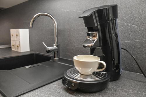 a coffee machine sitting on a kitchen counter with a cup at Vila Selena in Ljubljana