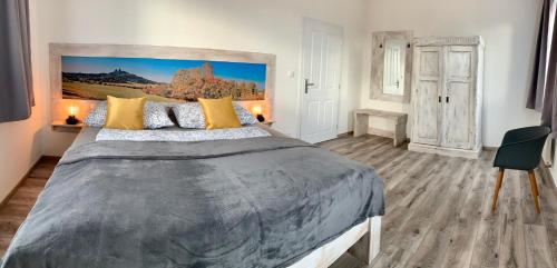 a bedroom with a large bed with yellow pillows at Penzion Holín u Prachovských skal in Jičín