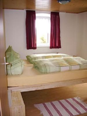 - une chambre avec des lits superposés et une fenêtre dans l'établissement Ferienhaus Neunkirchener- Mühle, à Daun