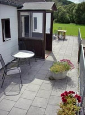 d'une terrasse avec une table, un banc et une table. dans l'établissement Ferienhaus Neunkirchener- Mühle, à Daun