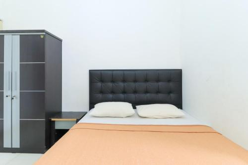 Bett mit schwarzem Kopfteil in einem Zimmer in der Unterkunft Riviera Residence in Balikpapan