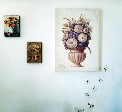 a painting of a vase of flowers on a wall at BiancoAmore OSTUNI - the sky, the sea, the love - in Ostuni