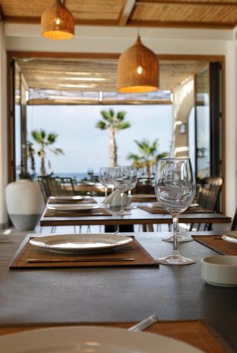 a dining room with a table with wine glasses at La Siesta Hotel & Beach Resort in Khaldah