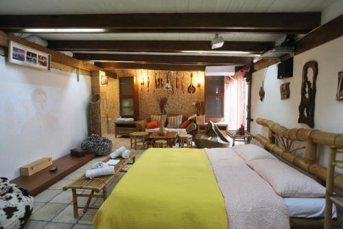 um quarto com uma grande cama amarela num quarto em Music House alle Grotte em Castellana Grotte