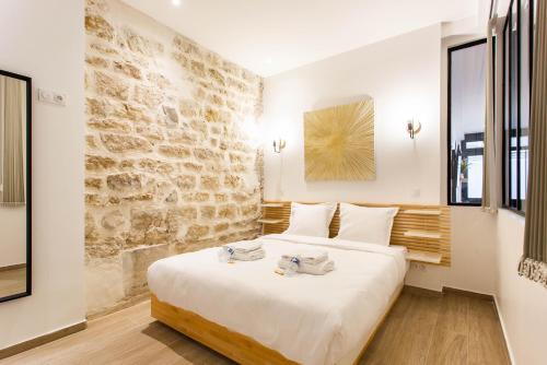 - une chambre avec un grand lit et un mur en pierre dans l'établissement CMG Marché d'Aligre - Nation D, à Paris