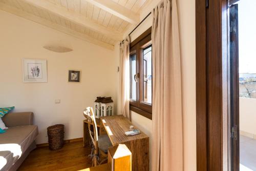 レティムノ・タウンにあるAnastasia's Venetian Houseのテーブルとベッド、窓が備わる客室です。