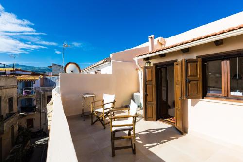 a balcony with chairs and a table on a building at Anastasia's Venetian House in Rethymno