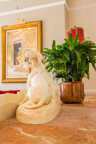 a dog statue sitting on a table next to a plant at Cedar House Boutique B&B in Burton