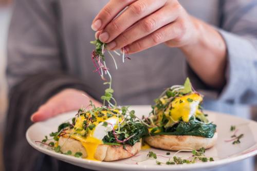 a person is holding a plate with food on it at The Junction Boutique Hotel in Plettenberg Bay