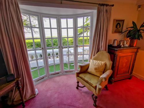 a living room with a chair and a large window at Cedar House Boutique B&B in Burton