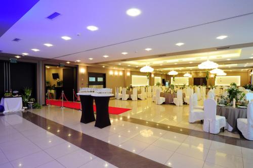 a banquet hall with white tables and white chairs at Hotel Zimnik Luksus Natury Spa & Wellness in Szczyrk
