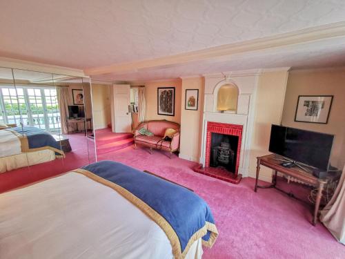 a bedroom with a bed and a fireplace at Cedar House Boutique B&B in Burton