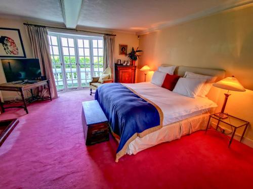a bedroom with a large bed and a large window at Cedar House Boutique B&B in Burton