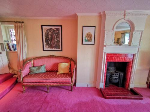 a living room with a red couch and a fireplace at Cedar House Boutique B&B in Burton