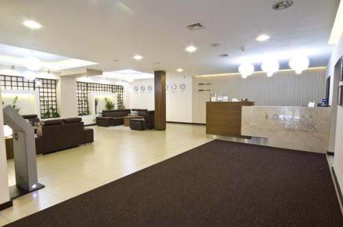 a lobby of a salon with couches and a counter at Hotel Zimnik Luksus Natury Spa & Wellness in Szczyrk