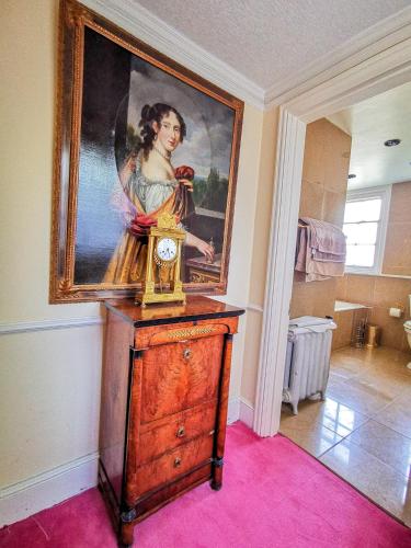 a painting of a woman on a dresser in a room at Cedar House Boutique B&B in Burton