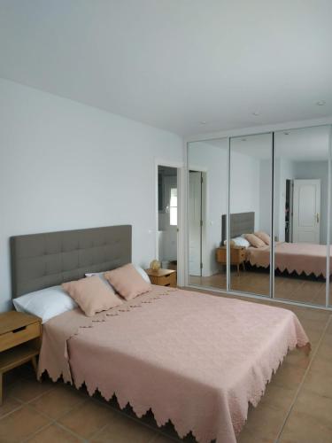 1 dormitorio con 1 cama grande y espejo grande en La Fresneda de Polendos, en Cabañas de Polendos