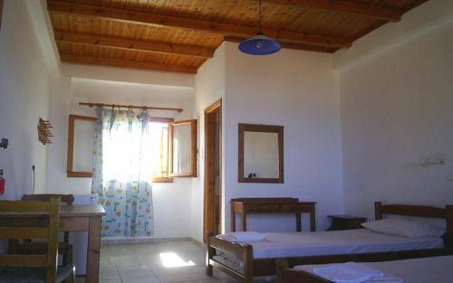 Habitación con 2 camas, mesa y ventana en Akrogiali en Gavdos