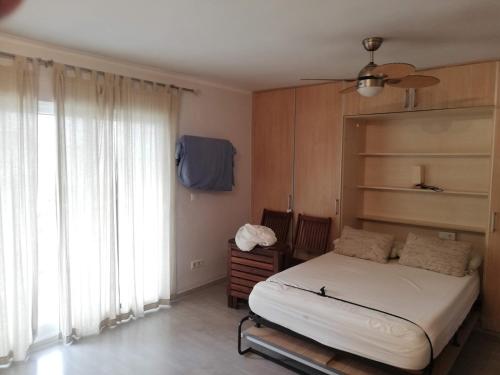 - une chambre avec un lit et une grande fenêtre dans l'établissement Estudios Solmar Solo Familias Serviplaya, à Gandía