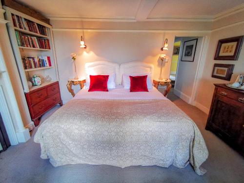 a bedroom with a large white bed with red pillows at Cedar House Boutique B&B in Burton