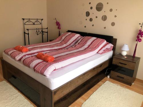 Schlafzimmer mit einem Bett mit einer roten und weißen Decke in der Unterkunft Corso Apartman in Kaposvár