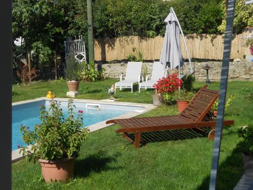 einen Hinterhof mit Pool, zwei Stühlen und einem Sonnenschirm in der Unterkunft Un bouquet de Tangissart in Villepinte