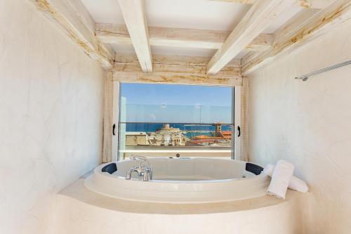 La salle de bains est pourvue d'une baignoire et offre une vue sur l'océan. dans l'établissement Rhodos Horizon City-Adults Only, à Rhodes