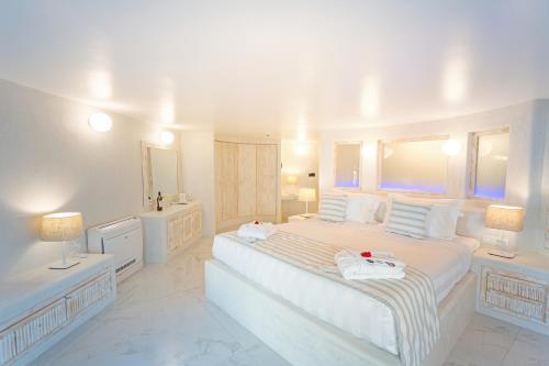 a white bedroom with a large bed with towels on it at Rhodos Horizon City-Adults Only in Rhodes Town