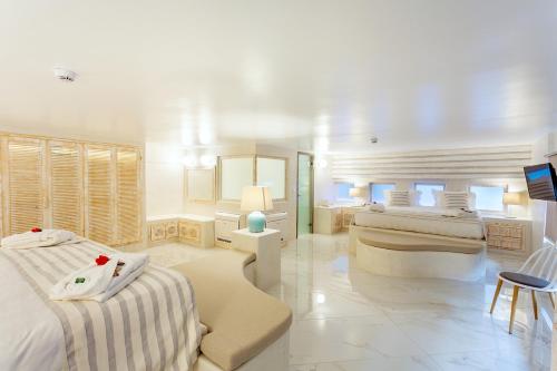 a white room with two beds and a tv at Rhodos Horizon City-Adults Only in Rhodes Town