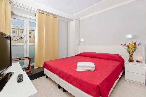 a bedroom with a red bed with a red blanket at Locanda Paradiso in Genova