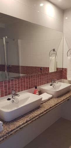 阿爾比爾的住宿－Camping La Colina，一间带两个盥洗盆和大镜子的浴室