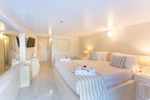a bedroom with a large bed with two stuffed animals on it at Rhodos Horizon City-Adults Only in Rhodes Town