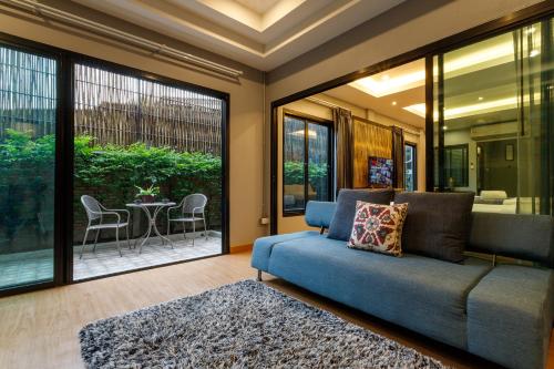 a living room with a blue couch and a patio at Hostel One Art and Gallery in Chiang Mai