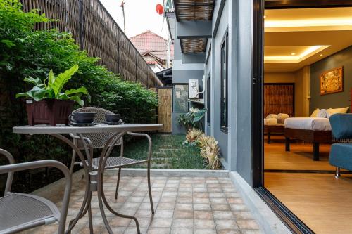 a patio with a table and chairs on a balcony at Hostel One Art and Gallery in Chiang Mai