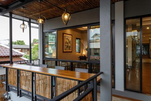 a balcony with a wooden table and chairs at Hostel One Art and Gallery in Chiang Mai