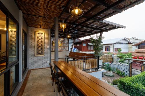 a patio with a wooden bench on a balcony at Hostel One Art and Gallery in Chiang Mai