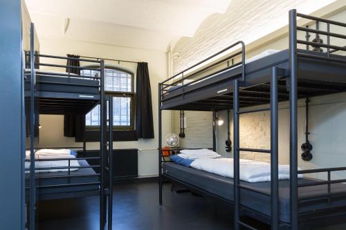 een kamer met twee stapelbedden en een raam bij Alibi Hostel Leeuwarden in Leeuwarden