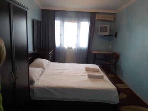 1 dormitorio con 1 cama con 2 toallas en Hotel Lika, en Batumi