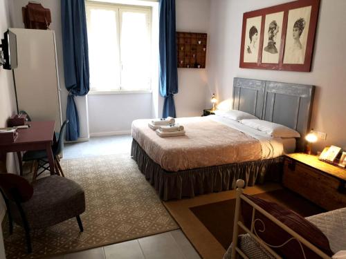 Schlafzimmer mit einem Bett, einem Schreibtisch und einem Fenster in der Unterkunft Interno Otto in Rom