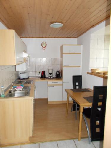 une cuisine avec un évier et une table avec des chaises dans l'établissement Ferienhaus Neunkirchener- Mühle, à Daun