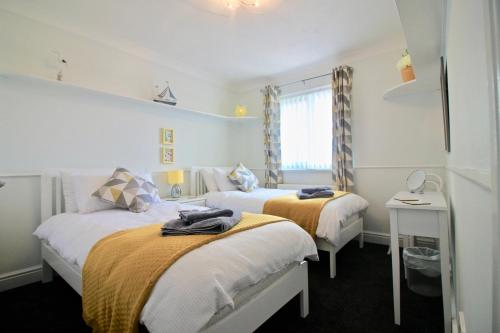 a bedroom with two beds and a window at Seascape in Clacton-on-Sea