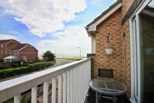 a balcony with a table and a view of a street at Seascape in Clacton-on-Sea