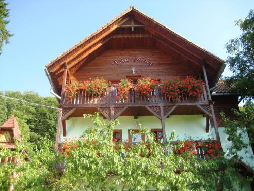 a wooden building with flowers on a balcony at Vila Anna in Sovata