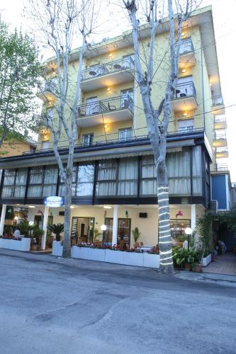 a building with two trees in front of it at Hotel Busignani in Rimini