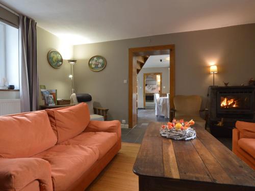 uma sala de estar com um sofá, uma mesa e uma lareira em Medieval farmhouse with private garden em Waimes
