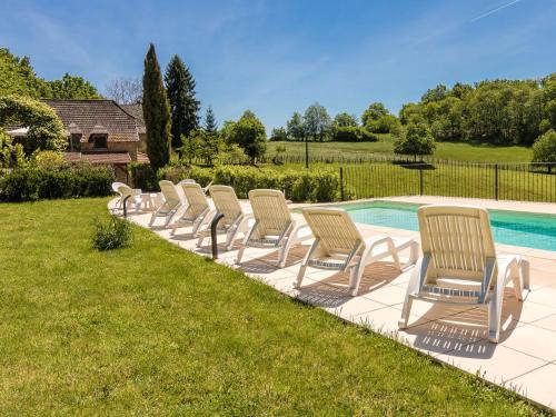 - une rangée de chaises assises à côté de la piscine dans l'établissement Holiday home in Altillac with private pool, à Altillac