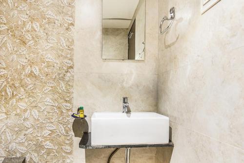 a bathroom with a white sink and a mirror at Hotel Horizon in Mumbai