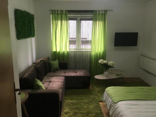 ein Wohnzimmer mit grünen Vorhängen und einem Sofa in der Unterkunft Apartment Green in Sarajevo