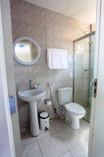 a bathroom with a sink and a toilet and a mirror at Hotel Terral in Pindoretama