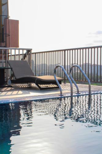 a swimming pool with a chaise lounge on a balcony at JVK Park Hotel in Cochin